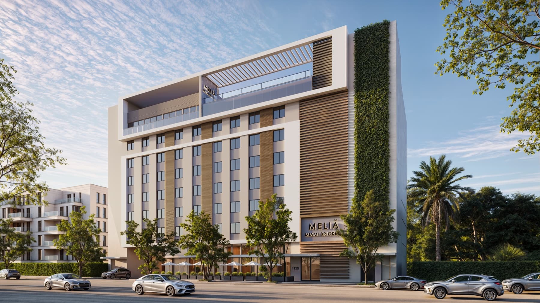 Architectural rendering of Meliá Miami Brickell Residences: a white tower with timber-slat screens and a full-height living green wall, above a tree-lined street.
