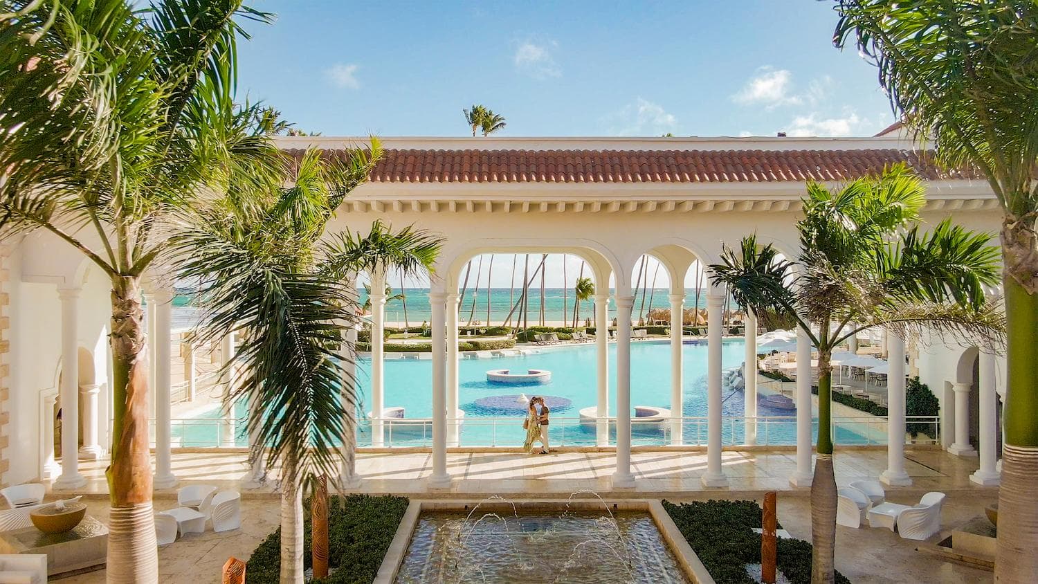 The colonnaded plaza and pool at Paradisus Palma Real, framed by palms.